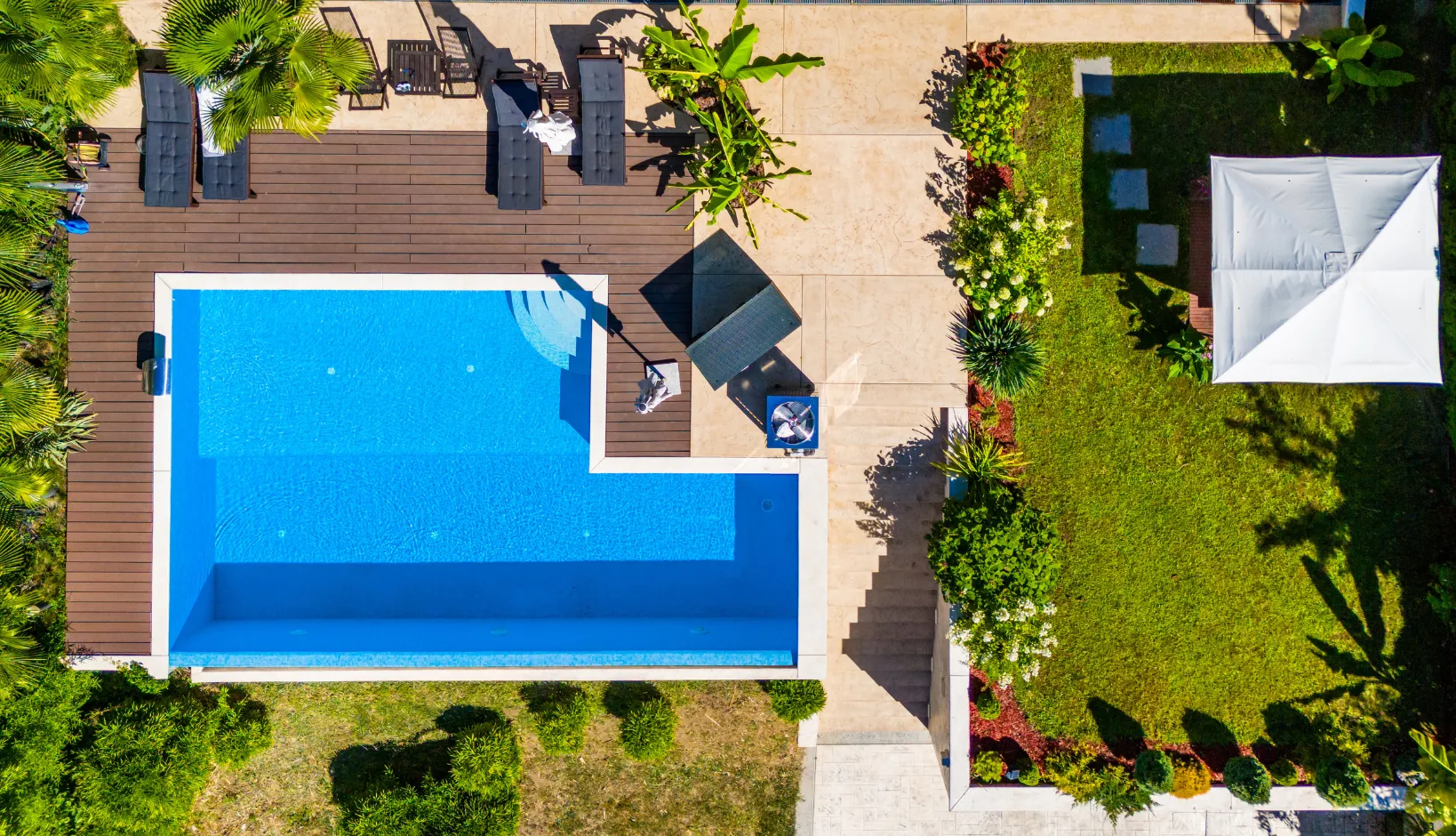 Remodeled backyard oasis with premium hardwood decking and a sleek new pool plaster finish in Southern California.