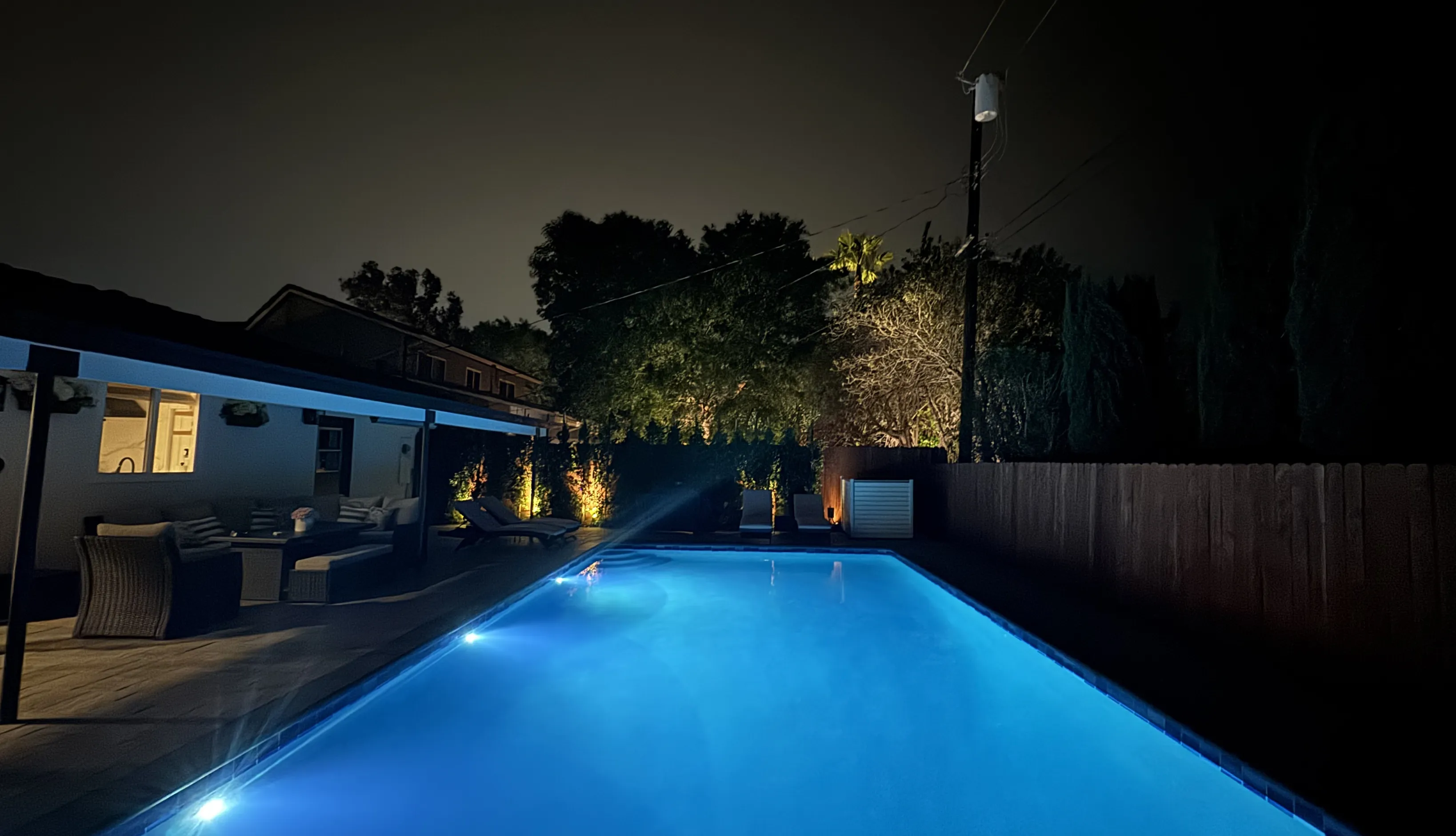 Contemporary blue tile lap pool design optimized for narrow backyard spaces in Southern California luxury homes